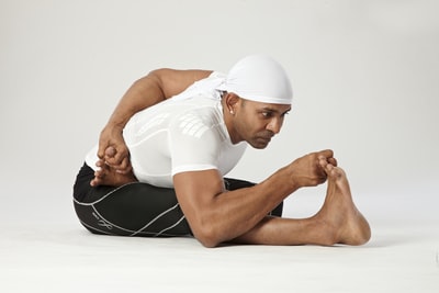 man in white tank top lying on white floor